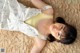 A woman laying on top of a bed wearing a yellow top.