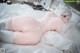 A woman laying on a bed in a white lingerie.