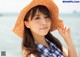 A woman wearing a straw hat on the beach.