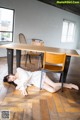 A woman laying on the floor next to a wooden table.