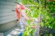 A woman with pink hair sitting on a ledge.