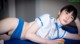 A woman in a blue and white uniform laying on a blue table.